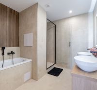 A bathroom in a 3-room apartment with a bathtub, shower corner, and designer tiles.