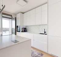Kitchen in a 4-room apartment with a wood-patterned floor and a view of the terrace.