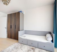 Children's room in a 4-room apartment with a bed, built-in wardrobe, and floor with wooden decor.