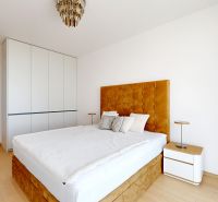 A bright bedroom with a bed and a wooden decor floor in a 4-room apartment.