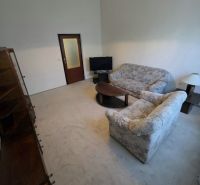 Living room with a sofa, table, and television in a three-room apartment.
