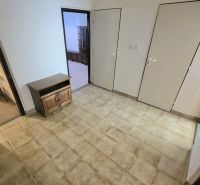 The interior of a 3-room apartment with a tiled floor and a wooden cabinet.