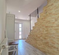 Entrance hall of a family house with a staircase featuring a stone design and a floor with a wood design.