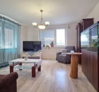 Living room in a family house with an aquarium, television, and wooden decor flooring.