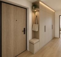 Entrance hallway in a 3-room apartment with a wooden decor floor and built-in wardrobes.