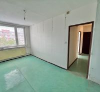 A room with windows, a green floor, white walls in a three-room apartment.