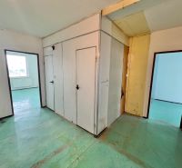 The interior of a 3-room apartment with white walls and a green floor in the hallway area.