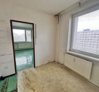 A room in a 3-room apartment with a view of a block of flats and a window with blinds.