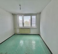A room with white walls and a green floor in a 3-room apartment.
