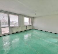 A spacious room in a 3-room apartment with large windows and a green floor.