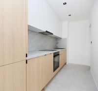 A minimalist kitchen in a 3-room apartment with wooden decor and white cabinets.
