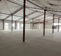 Spacious interior of a warehouse and hall with white walls and steel beams.
