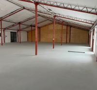 A spacious interior of a hall with iron beams and a white ceiling.