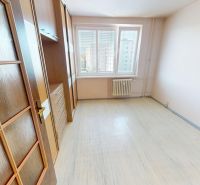 A room with a wooden floor design and large windows in a 3-room apartment.