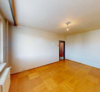 A spacious room with a wooden decor floor and a large window, 3-room apartment.