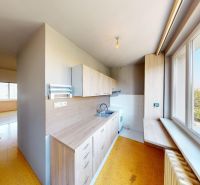 A kitchen with wooden decor and windows in a 3-room apartment with a view of nature.