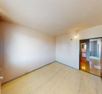 A room of a 3-room apartment with a wooden decor floor and a wardrobe.