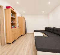 A comfortable sofa set and storage furniture in a studio apartment with a wooden decor floor.