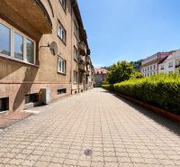 A city street with apartment buildings and a well-maintained sidewalk.