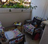 Balcony with colorful chairs and flowers, part of a 1-room apartment.