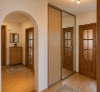 A hallway with a wooden decor floor and a built-in wardrobe in a 3-room apartment.