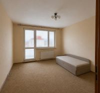 A room in a 3-room apartment with a carpet and a simple bed, bright walls.