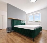 A bedroom in a holiday apartment with a bed and a wooden decor floor.