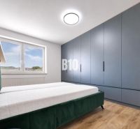Bedroom in a holiday apartment with a comfortable bed and wooden decor flooring.