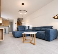 Recreational apartment with a blue sofa, a rectangular table, and plenty of light in the interior.