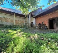 An older house with a garden and a crumbling facade in Nová Vieska, suitable for residential land.