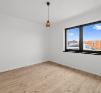 A room in a family house with white walls and a wooden decor floor.