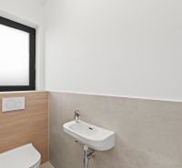 Small toilet in a family house with a window and a narrow sink.