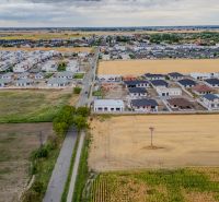 Aerial view of family houses on Višňová Street in Hviezdoslavov surrounded by fields.