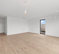 A room in a family house with white walls and a wooden decor floor.
