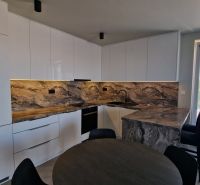 A kitchen with marble decor in a 3-room apartment and a window to the balcony.
