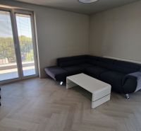 Living room with a corner sofa, coffee table, and floor with wood decor.