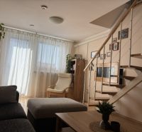 Living room with seating area, staircase, and wood-patterned flooring in a 4-room apartment.