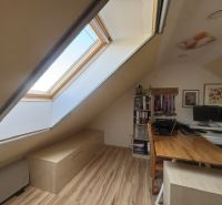 An attic office with a skylight and a wooden decor floor in a 4-room apartment.