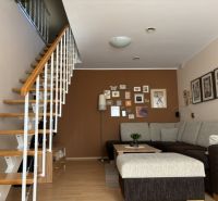 Living room of a 4-room apartment with a wooden decor floor and a staircase.