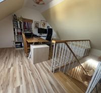 Attic office in a 4-room apartment with wood-patterned flooring and a desk.