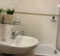 A bathroom with a mirror and a sink in a 4-room apartment with white tiles.