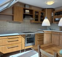 A kitchen in a 4-room apartment with a wooden decor floor and built-in appliances.