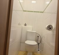 Toilet in a 4-room apartment with white tiles and a toilet.