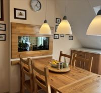 A dining room with a solid wood table in a 4-room apartment with wooden decor.