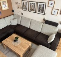 A living room in a 4-room apartment with a sofa and a wall with artworks.