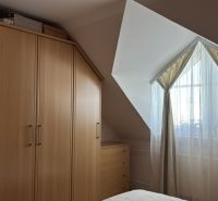 A bedroom in a 4-room apartment with a corner wardrobe and a skylight.