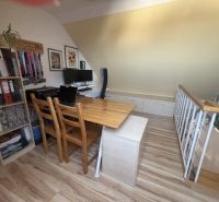 Attic office with a desk and drawers in a 4-room apartment with a wooden decor floor.