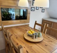 Dining area in a 4-room apartment with a table and a decorative aquarium on the wall.