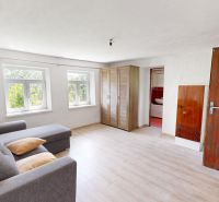 The interior of the family house offers a bright room with a sofa and a wardrobe.