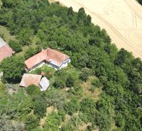 A family house on Kamenec Street in Vrbovce surrounded by greenery and fields.